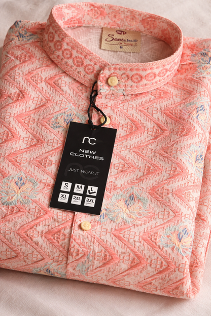 Pink patterned kurta folded with a tag on a light background