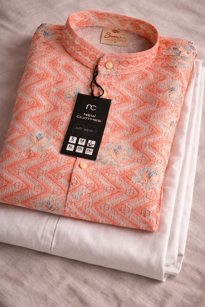 Folded pink patterned shirt with a tag on a light background